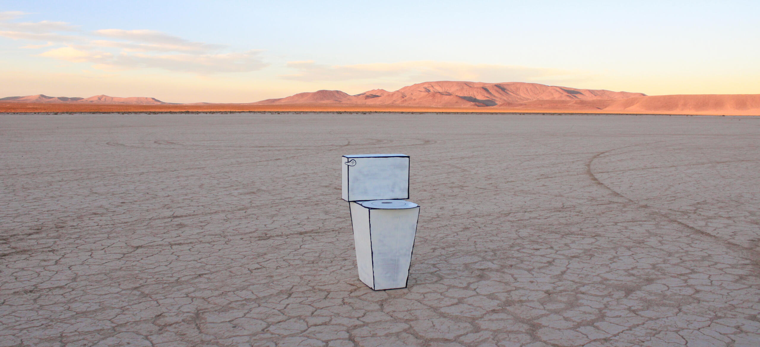 Image of sculpture by Kayla Lockwood. Features cardboard toilet painted white with desert landscape behind it.